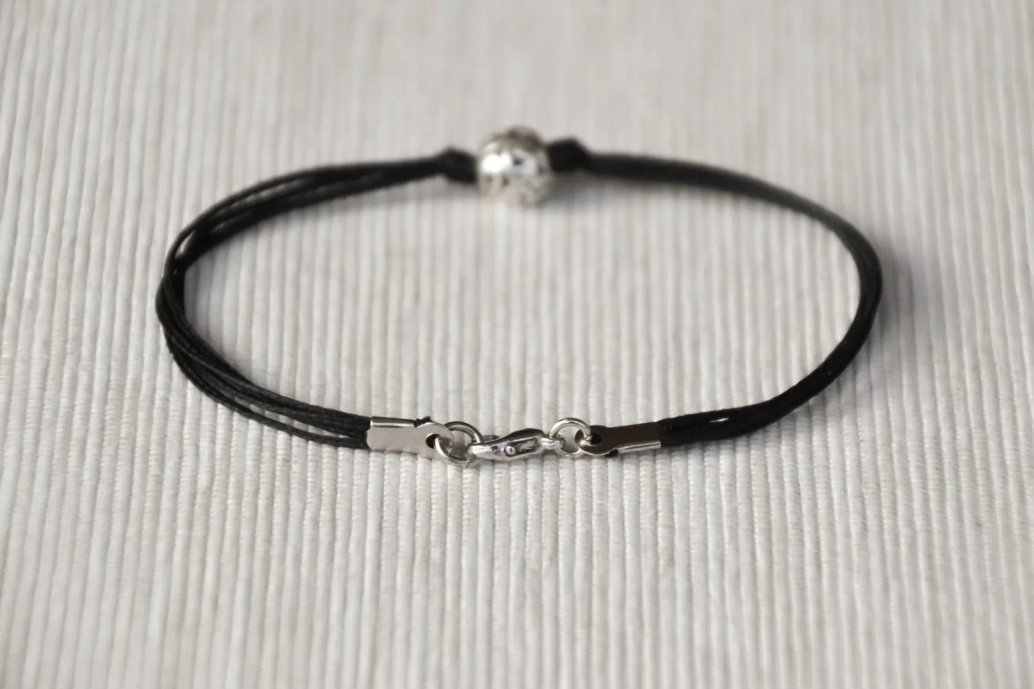 Men's bracelet with silver bead charm and a black cord